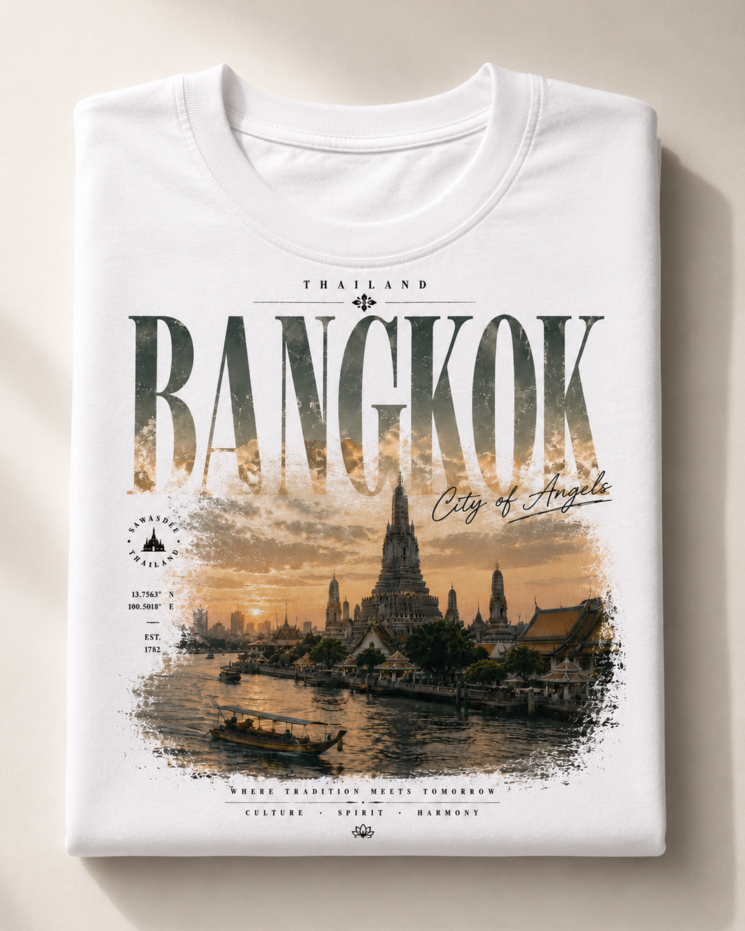 A folded white t-shirt with a detailed graphic print of Bangkok, Thailand, featuring the word &