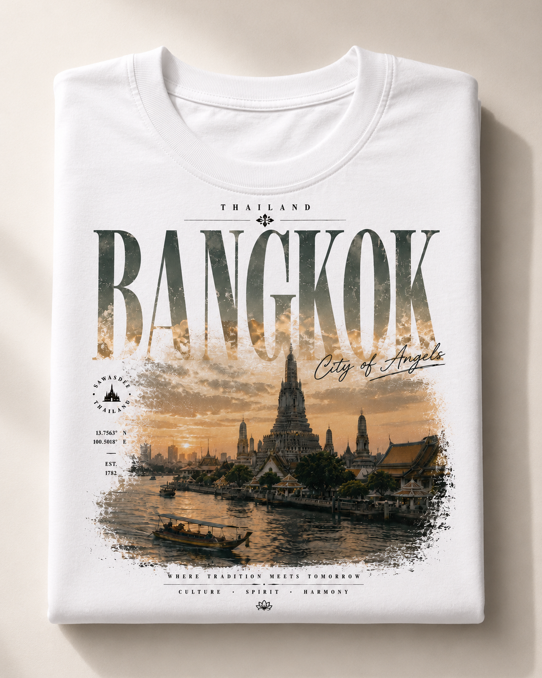 A folded white t-shirt with a detailed graphic print of Bangkok, Thailand, featuring the word 'BANGKOK' in large textured letters over a sunset cityscape illustration.