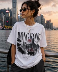 Person wearing a white t-shirt with 'Hong Kong' design against a cityscape background