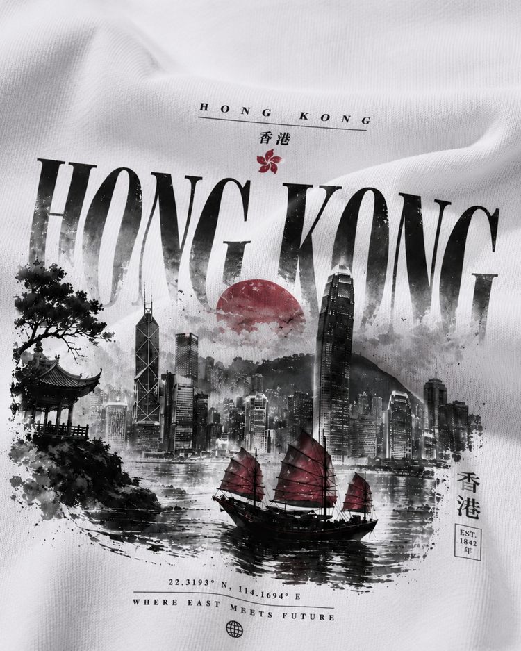 A close-up of a white fabric surface printed with a Hong Kong cityscape graphic. The design includes large black 'HONG KONG' text, a red sun, black-and-white skyscrapers, a red-raked junk boat on water, and small Chinese characters.