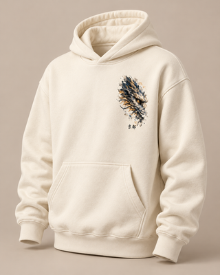 An off-white hooded sweatshirt with a kangaroo pocket, featuring a stylized feather graphic in navy, gold, and brown on the left chest, displayed on a neutral beige background.